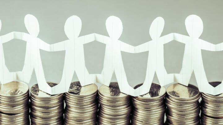 Paper chain of people standing on coins to represent crowdfunding