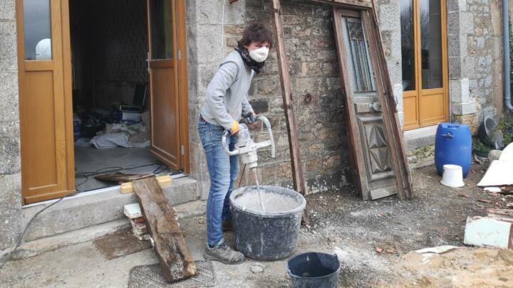 Woman mixing contents with an industrial mixer in a tub