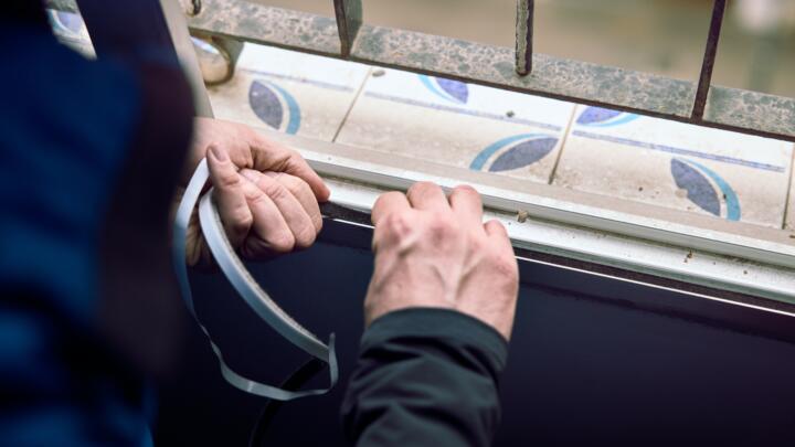 Installing weather-stripping on a window.